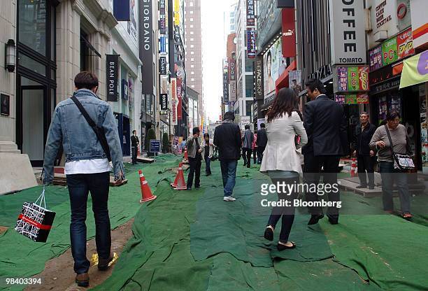 Pedestrians walk through a shopping district in Seoul, South Korea, on Monday, April 12, 2010. South Korea's economy will expand this year at the...