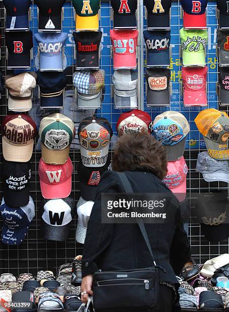 Shopper looks at baseball caps displayed in Seoul, South Korea, on Monday, April 12, 2010. South Korea's economy will expand this year at the fastest...