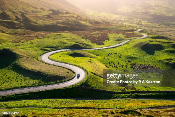 car driving in the hills of england on a sunny evening - country road stock pictures, royalty-free photos & images