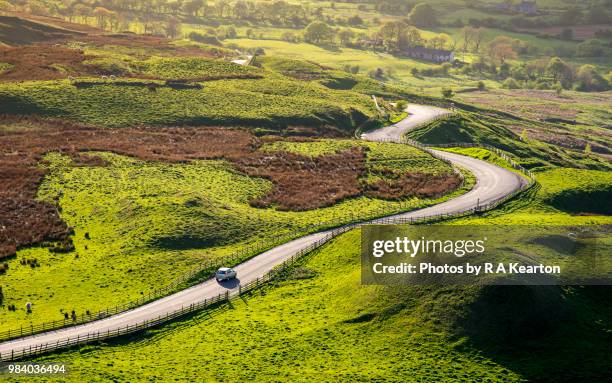 car driving in the hills of england on a sunny evening - holprig stock-fotos und bilder