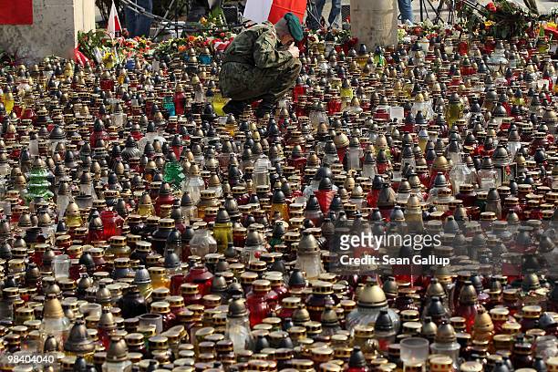 Polish soldier arranges candles left by mourners outside the Presidential Palace in memory of late Polish President Lech Kaczynski on April 12, 2010...