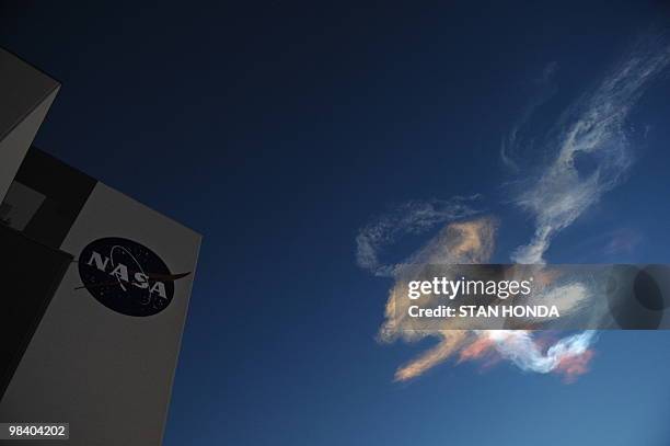 Contrails from the space shuttle Discovery are seen near the Vehicle Assembly Building just after launch on April 5, 2010 at the Kennedy Space Center...