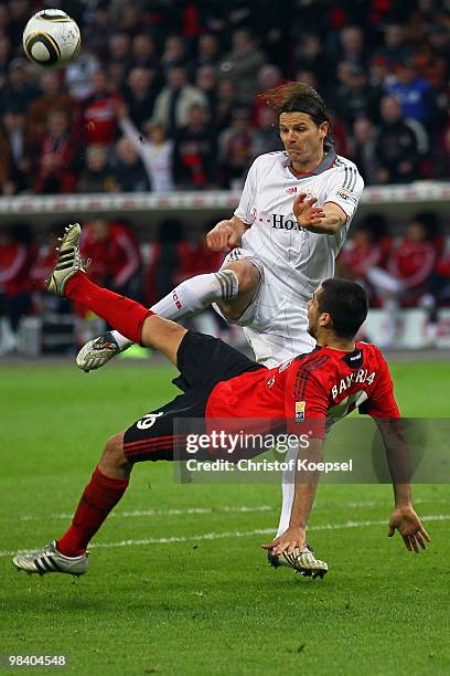 Daniel van Buyten of Bayern challenges Eren Derdiyok of Leverkusen during the Bundesliga match between Bayer Leverkusen and FC Bayern Muenchen at the...