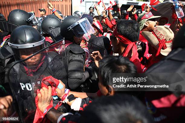 Red Shirt supporters of former Prime Minister Thaksin Shinawatra clash with riot police while shouting slogans during a funeral procession for the...