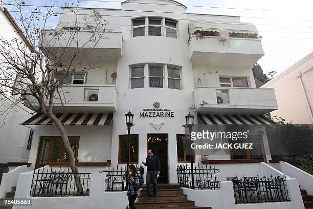 Pedestrians leave a Bauhaus-style building in Tel Aviv, on February 22, 2010. Tel Aviv, named the White City for its collection of over 4,000 Bauhaus...