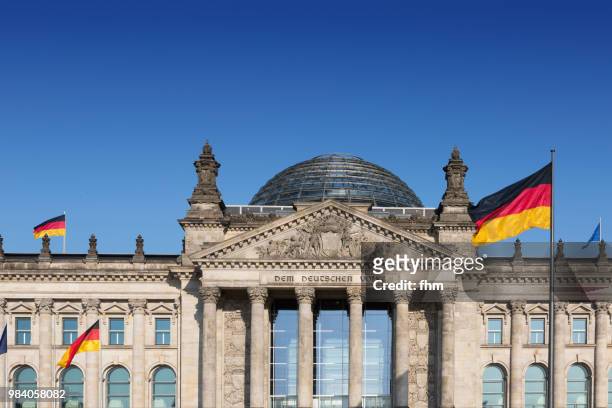 reichstag building with german flags (german parliament building) - berlin, germany - architrave stock pictures, royalty-free photos & images