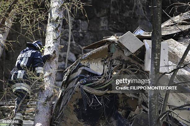 Rescuer searches near a passenger train which was thrown from its tracks by a landslide in mountains near Laces and Castebello, near the northern...