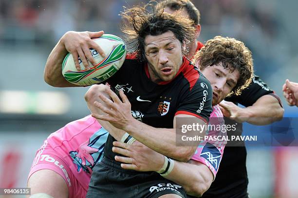 Toulouse's scrum-half Byron Kelleher is tackled by Paris lock Pascal Pape during their European Cup quarter-final match Toulouse vs. Paris on April...