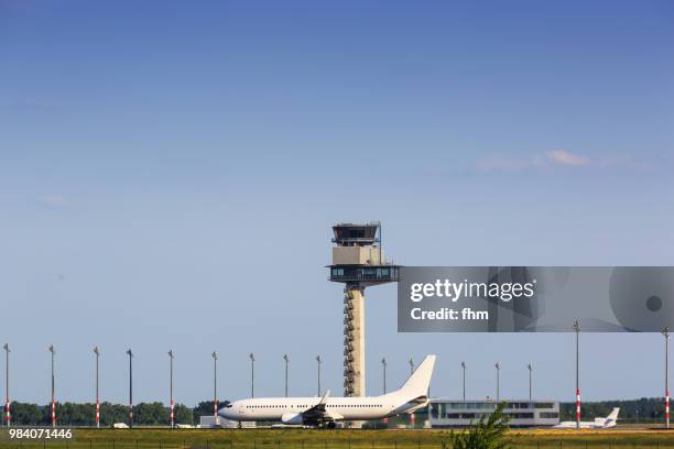 a passenger airplane was strarting at schönefeld airport (brandenburg, germany) - flughafen berlin schönefeld stock-fotos und bilder
