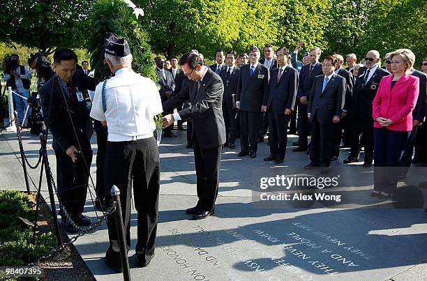 Korean President Lee Myung-bak lays a wreath as U.S. Secretary of State Hillary Rodham Clinton looks on during a visit to the Korean War Memorial to...