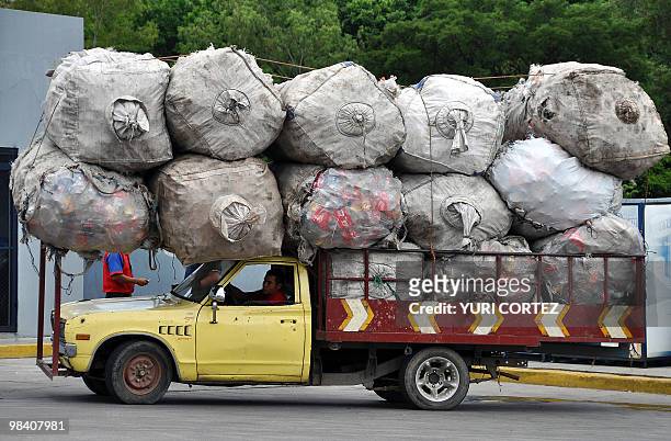 Man drives his truck loaded with plastic containers to be recicled, at the North highway on October 19, 2009 in Tegucigalpa. AFP PHOTO/Yuri Cortez