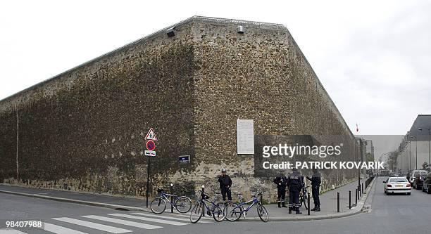 Policemen stand in the security perimeter around La Santé prison in Paris set following an hostage situation on April 07, 2010. A jailhouse doctor is...