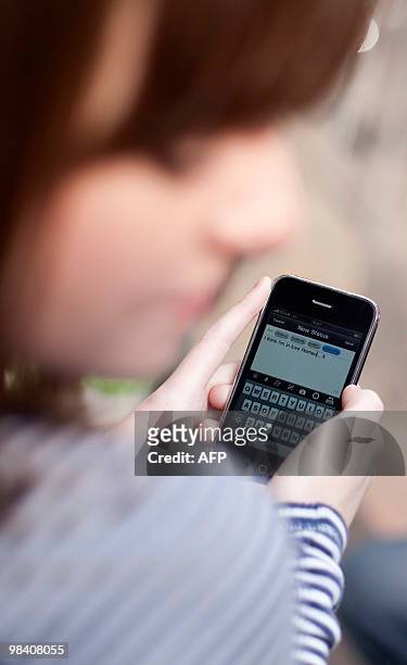 Actress Charlotte Wakefield holds her phone as she plays the role of Juliet during a photocall for the "Such Tweet Sorrow", a 'Twitter' version of...