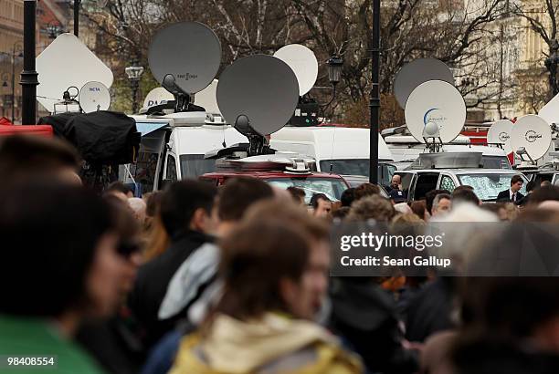 Satellite dishes on media vans stand behind mourners who had come to pay last respects to late Polish President Lech Kaczynski outside the...