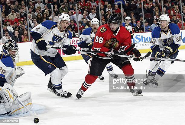 Patrick Kane of the Chicago Blackhawks, Eric Brewer and Brad Boyes of the St. Louis Blues skate toward the puck as Andy McDonald of the Blues...