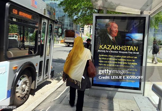 Woman walks towards an arriving bus near an ad from the Kazakhstan government promoting a nuclear weapons free world in a bus stop April 12 in...