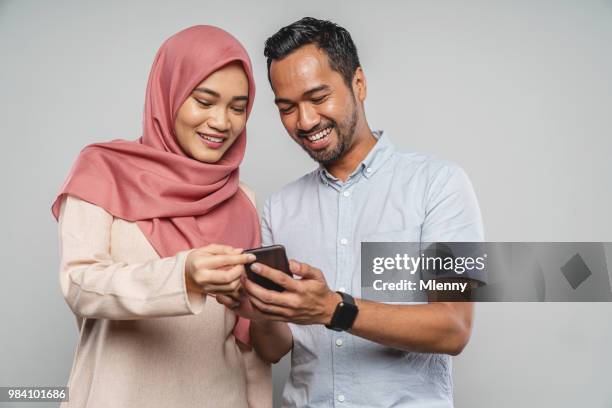 aziatische jong koppel met slimme telefoon - young muslim man stockfoto's en -beelden