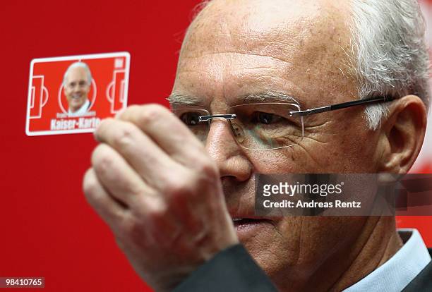 Franz Beckenbauer holds up the 'Franz Beckenbauers Kaiser-Karte' at a news conference during his visit to Axel Springer publishing house on April 12,...