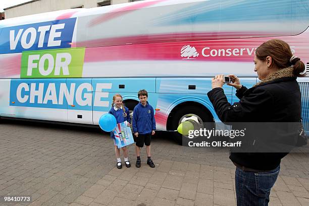 Conservative party supporter takes a photograph of her son Harry and daughter Lottie in front of the Conservative battle bus after party leader David...