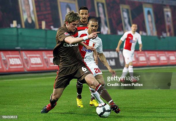 Bastian Oczipka and Deniz Naki of St. Pauli and Marcel Ndjeng of Augsburg compete for the ball during the Second Bundesliga match between FC St....