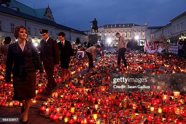 Members of the Polish military depart after visiting a sea of candles left by mourners outside the Presidential Palace in memory of late Polish...