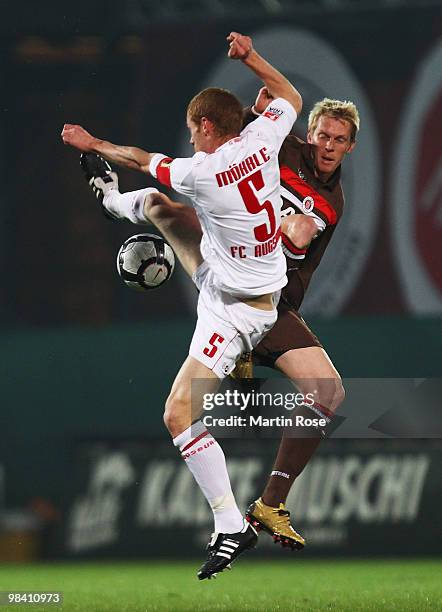 Marius Ebbers of St. Pauli and Uwe Moehrle of Augsburg battle for the ball during the Second Bundesliga match between FC St. Pauli and FC Augsburg at...