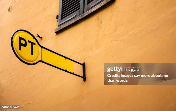 a post office sign with its vibrant color. street in barolo, italy. - postkontor bildbanksfoton och bilder