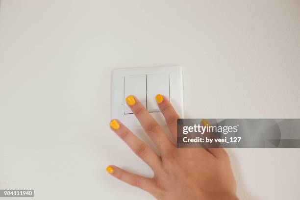 a girl's hand switching lights on or off - light switch stock pictures, royalty-free photos & images