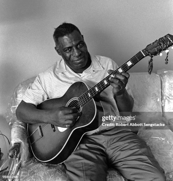 Portrait of blues musician Chester Arthur Burnett better known as Howlin' Wolf, posing with his guitar, during an interview for the Chicago Defender,...