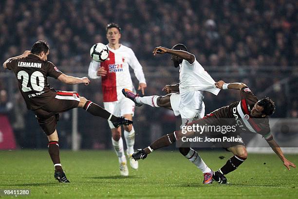 Matthias Lehmann and Fabio Morena of St. Pauli and Nando Rafael of Augsburg compete for the ball during the Second Bundesliga match between FC St....