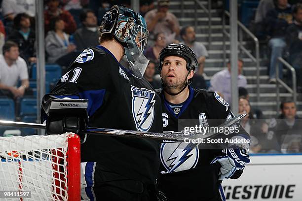 Martin St. Louis of the Tampa Bay Lightning talks with goaltender Mike Smith during a break in the action against the Carolina Hurricanes at the St....
