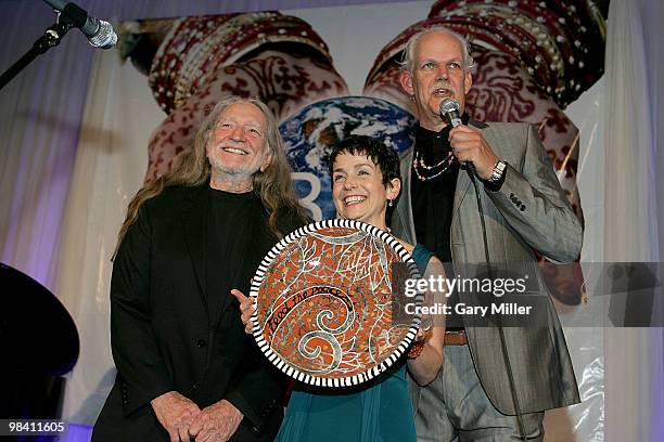 Musician Willie Nelson, Christy Pipkin and social activist/author/filmmaker Turk Pipkin present the Nobelity Project's "Feed The Peace" award to...