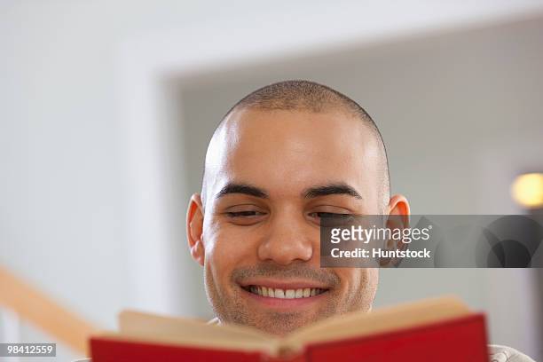 hispanic man reading a book - look down - fotografias e filmes do acervo