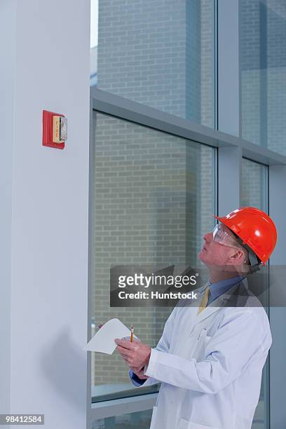 engineer inspecting fire alarm in a building - 庇護者 ストックフォ��トと画像