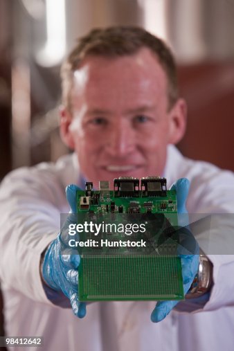Engineer showing a micro controller circuit board Engineer showing a micro controller circuit board