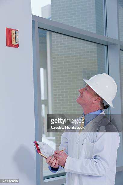engineer inspecting fire alarm in a building - 庇護者 ストックフォトと画像
