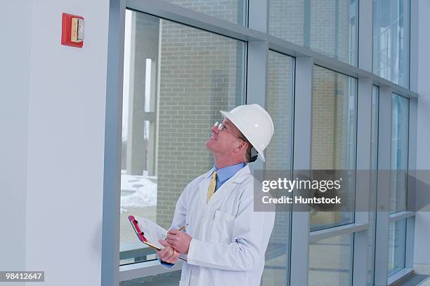 engineer inspecting fire alarm in a building - 庇護者 ストックフォトと画像