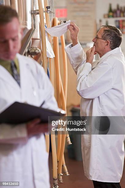 two scientists making reports in a brewery - industrial hose stockfoto's en -beelden