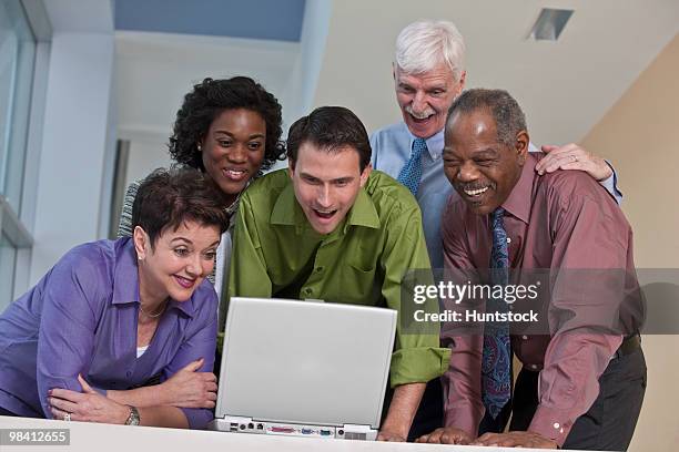 business executives using a laptop and smiling - massachusetts conference for women stock-fotos und bilder