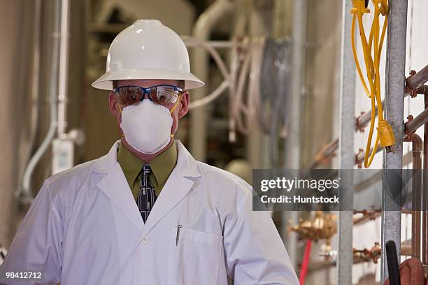 engineer wearing a pollution mask in a chemical plant - industrial hose stockfoto's en -beelden