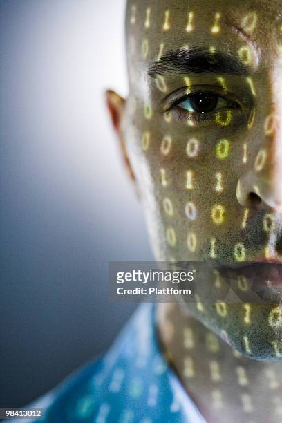 close-up of a man with digital numbers reflected on his face. - face projection stock pictures, royalty-free photos & images
