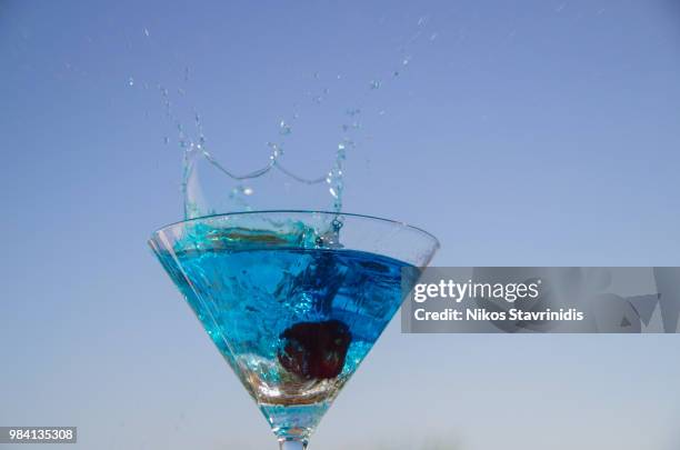 blue splash - blue martini glasses stock-fotos und bilder