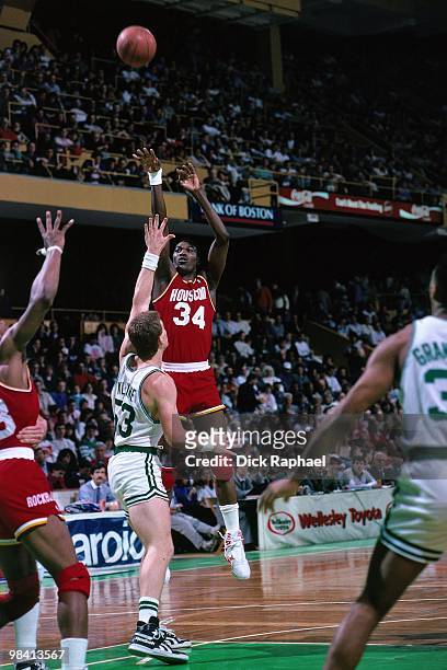 Hakeem Olajuwon of the Houston Rockets shoots a jump shot against Joe Kleine of the Boston Celtics during a game played in 1989 at the Boston Garden...