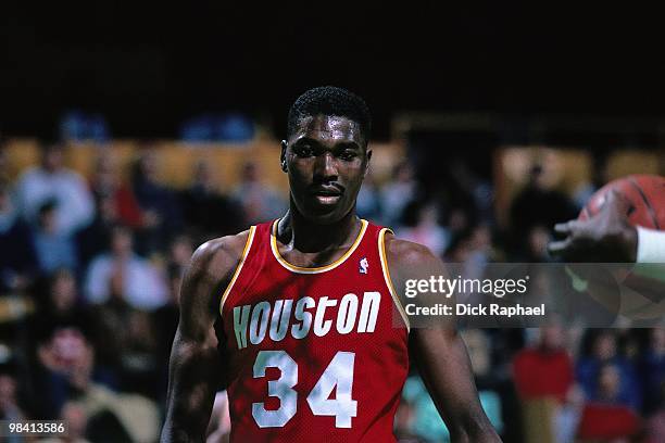 Hakeem Olajuwon of the Houston Rockets looks on against the Boston Celtics during a game played in 1989 at the Boston Garden in Boston,...