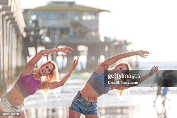 zwillinge, die ausübung bei sonnenuntergang am strand - lisegagne stock-fotos und bilder