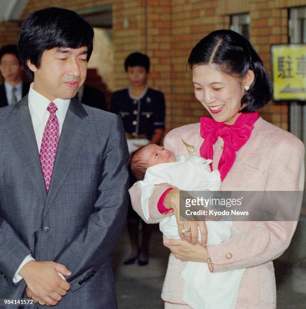 Photo taken in September 1990 shows Japanese Prince Takamado and his wife Princess Hisako holding their third daughter Princess Ayako in front of...