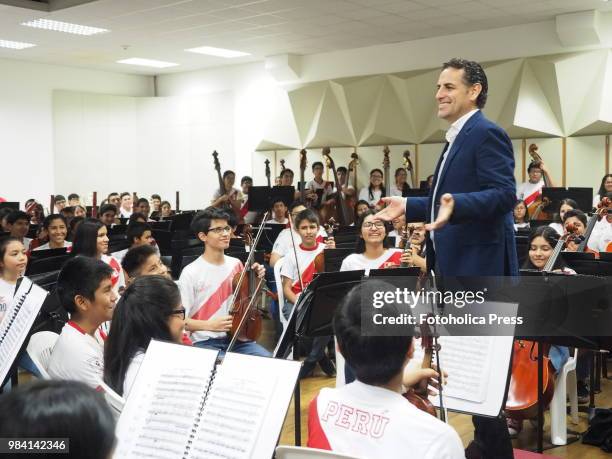 The operatic tenor Juan Diego Florez, together with the children of the Symphony for Peru Orchestra wearing Peruvian soccer jerseys, singing to the...