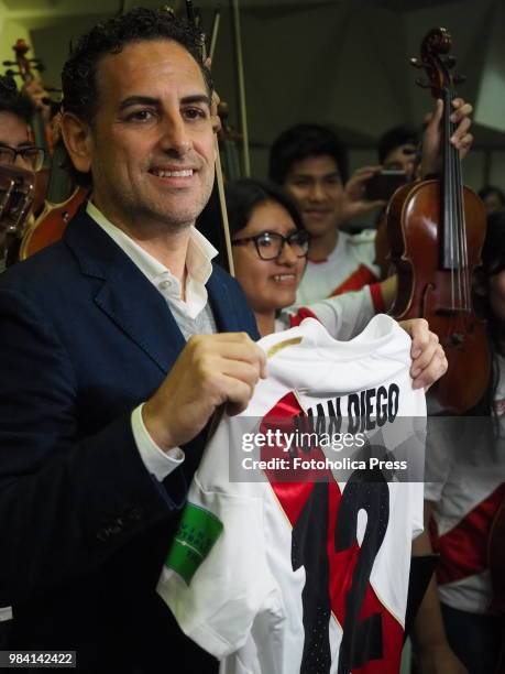 The operatic tenor Juan Diego Florez, together with the children of the Symphony for Peru Orchestra wearing Peruvian soccer jerseys, singing to the...