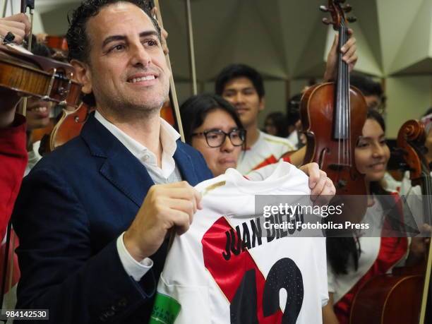 The operatic tenor Juan Diego Florez, together with the children of the Symphony for Peru Orchestra wearing Peruvian soccer jerseys, singing to the...