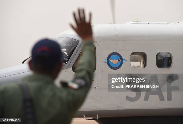 An Indian test pilot with Hindustan Aeronautics Limited waves at Seychelles Air Force pilots taking off after the handover ceremony of a Dornier...